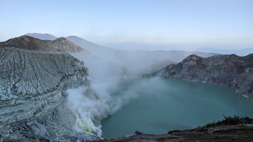 Smoke emitting from volcanic mountain against sky