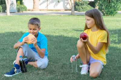 Children schoolchildren eat lunch in the park. harmful and healthy food.