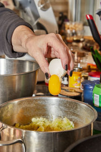 Chef cracks an egg into dish that is being prepared in bowl