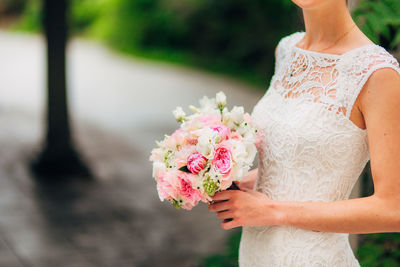 Midsection of woman holding flower bouquet