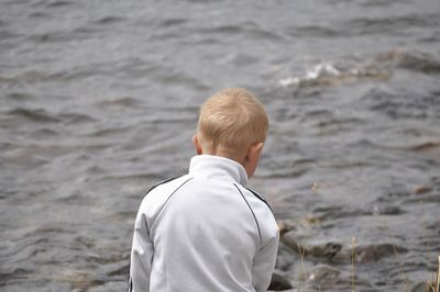 Rear view of boy standing at beach