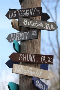 Low angle view of information signs on wooden post outdoors
