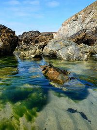 Rocks in sea against sky