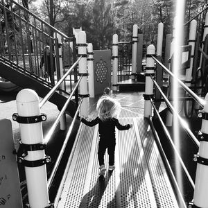 Rear view of woman walking on staircase in city