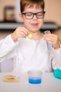 Boy is engaged in scientific research. a child with a test tube and a pipette in his hands. 