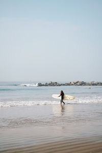 Man on beach against clear sky