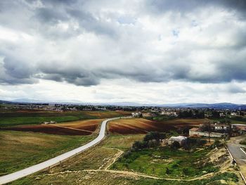 High angle view of road amidst field against sky