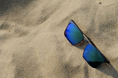 High angle view of sunglasses on beach