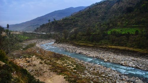 Scenic view of river amidst mountains against sky