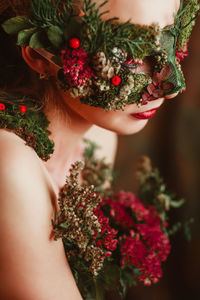 Close-up of woman with flower mask looking away