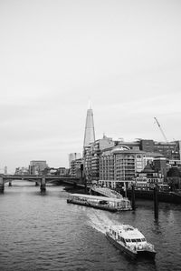 Boats in river with buildings in background