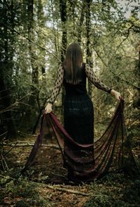 Rear view of woman on rope in forest