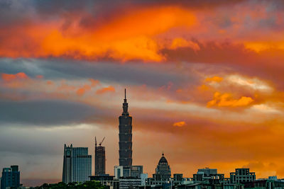 Buildings in city against sky during sunset