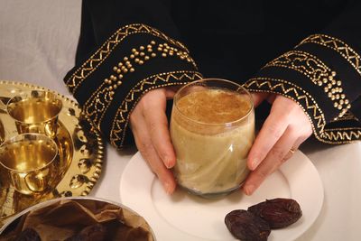 Midsection of woman drinking balah bel laban  