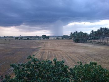 Scenic view of field against cloudy sky