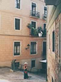 Full length rear view of man standing on street against building