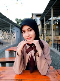 Portrait of young woman sitting outdoors