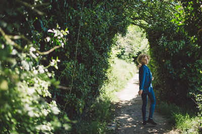 Full length of woman walking amidst plants at park