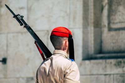 Rear view of man standing against wall