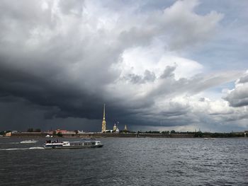 Ship in sea against cloudy sky