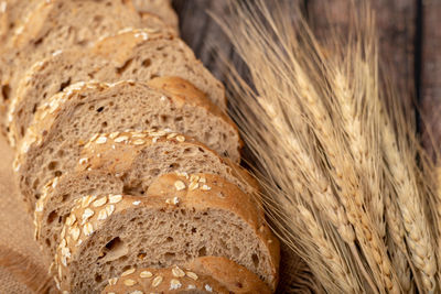 Breads sliced and wheatgrass on the sack with a wooden table