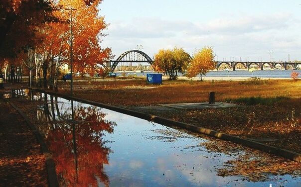 water, tree, reflection, built structure, connection, architecture, sky, bridge - man made structure, river, cloud - sky, waterfront, tranquility, nature, lake, outdoors, tranquil scene, park - man made space, bridge, no people, arch bridge