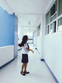 Side view of woman standing in corridor