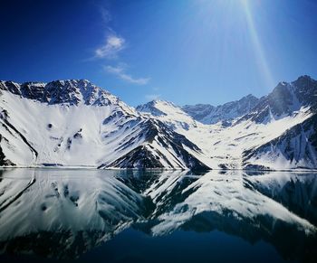 Scenic view of lake and mountains against blue sky