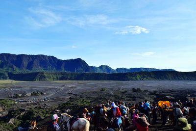 Group of people on landscape against sky
