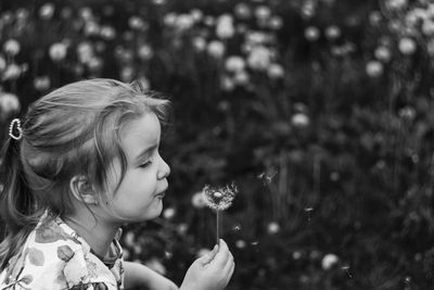 Close-up of girl holding dandelion