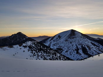 Scenic view of snowcapped mountains against sky during sunset