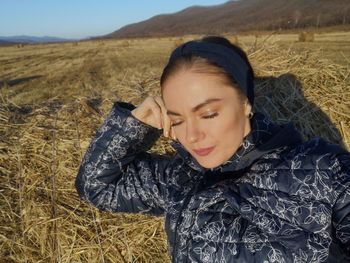 Portrait of young woman lying on field