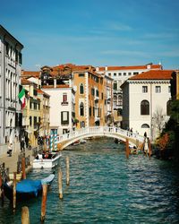 Canal amidst buildings in city against sky