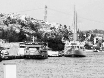 Sailboats moored on river by trees