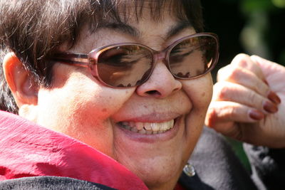 Close-up portrait of cheerful woman wearing sunglasses