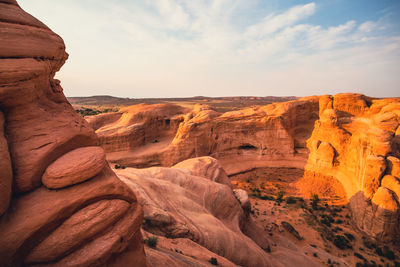 Scenic view of rock formations against cloudy sky