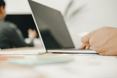 Midsection of man using laptop on table