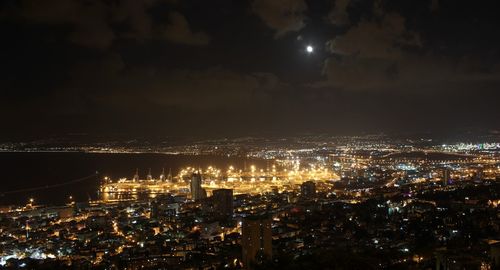 Illuminated cityscape against sky at night