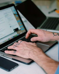 Cropped image of man using laptop