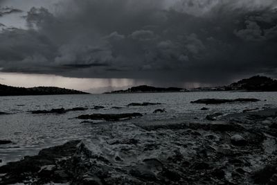 Scenic view of sea against storm clouds