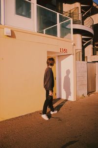 Full length of man standing on street against building