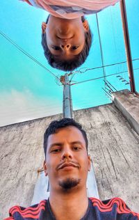 Portrait of smiling young man against blue sky