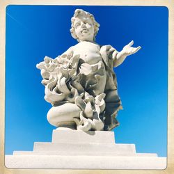 Low angle view of statue against blue sky