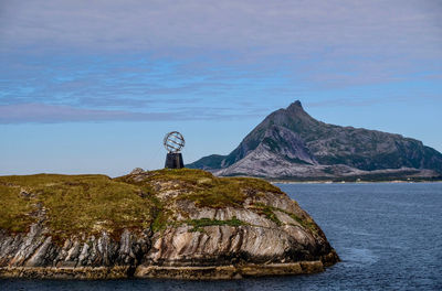 Rock formations by sea against sky