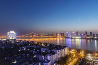 Illuminated city buildings against sky at night