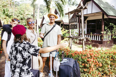 Happy family with luggage arriving at tourist resort during vacation