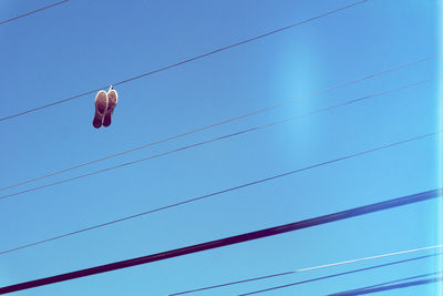 Low angle view of shoes hanging on cable
