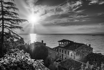 Scenic view of sea by buildings against sky