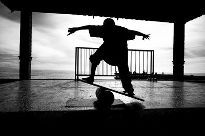 Rear view of boy balancing on plank at gazebo