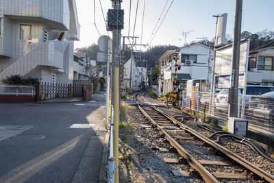 Railroad tracks amidst buildings in city against sky